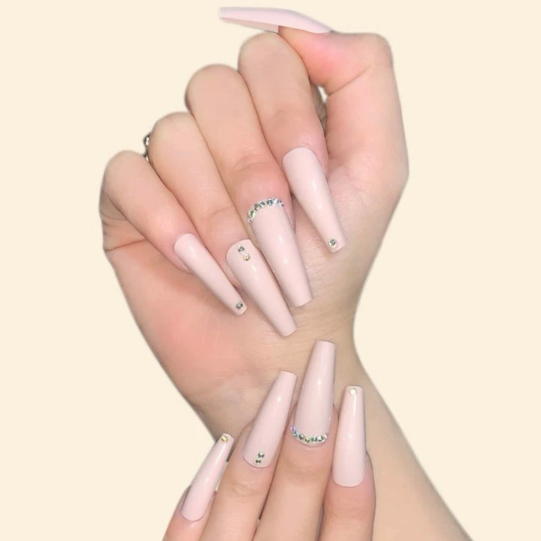 long coffin nude coloured press on nails with elegant gem stones placed throughout